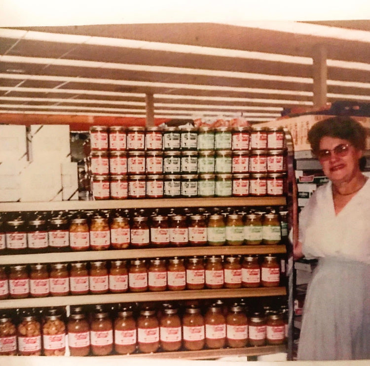 Gertrude — "Mrs. Sassard" — with a full grocery display of her relishes, pickles and preserves.